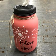 a pink mason jar with a dandelion painted on it and the words, bless you