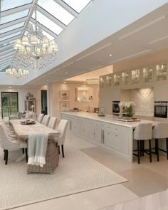 a large open kitchen and dining room area with skylights above the countertop, along with white cabinets