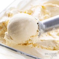 a scoop of ice cream in a glass container with a metal spoon on it,