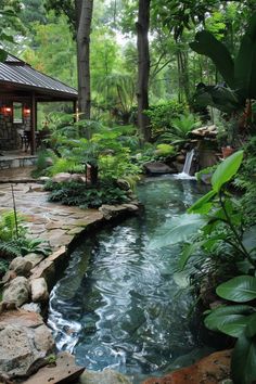 a small pond in the middle of a garden with lots of plants and rocks around it