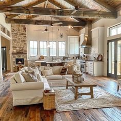 a living room filled with furniture and a fire place in the middle of an open floor plan