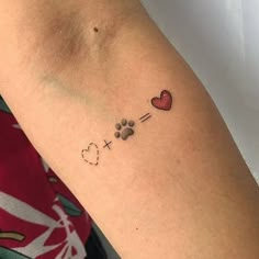 a woman with a tattoo on her arm has a dog paw and heart in it