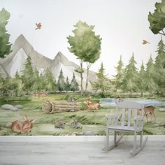 a wall mural with animals and trees in the background, along with a rocking chair