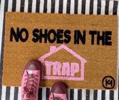 someone wearing pink shoes standing in front of a door mat that says no shoes in the trap