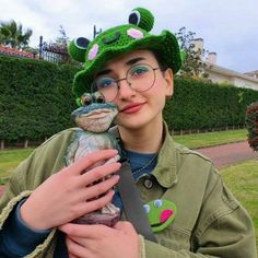 a boy in glasses and a green hat holding a stuffed animal