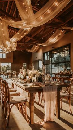 a long table with chairs and lights hanging from it's ceiling in a large room