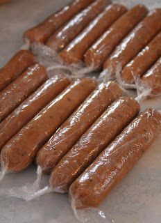 several sausages are wrapped in plastic on the counter