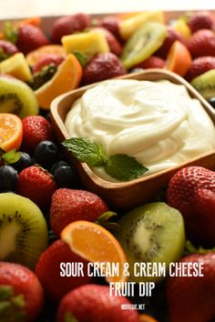 sour cream and cream cheese fruit dip in a wooden bowl surrounded by fresh cut fruits