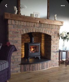 a living room with a fire place in the center and a couch next to it