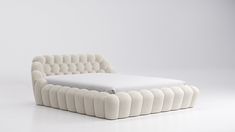 a white bed sitting on top of a white floor