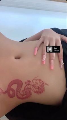 a woman with pink nail polish laying on her stomach and holding onto the side of her body