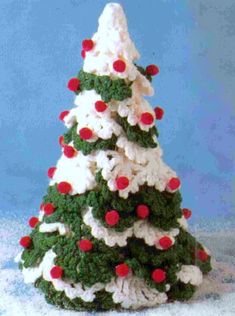 a crocheted christmas tree with red and white balls on it's top