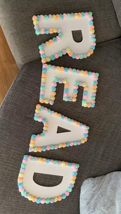 the letters are made out of cake and frosted with sprinkles on them