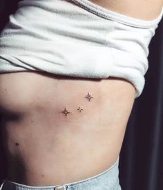 a woman's stomach with three small stars on the side and one behind her