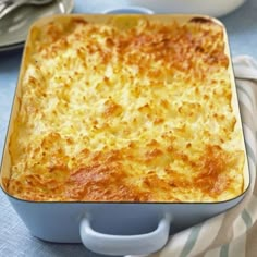 a casserole dish is shown on a blue table cloth with silverware in the background