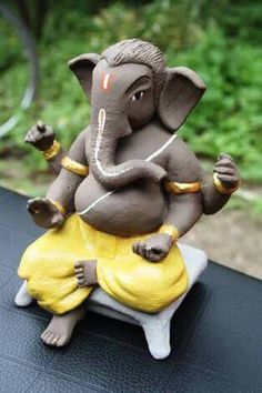 an elephant figurine sitting on top of a table with grass in the background