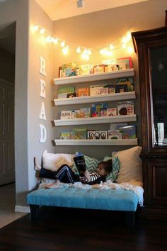 a living room filled with furniture and lots of shelves on the wall above it's headboard