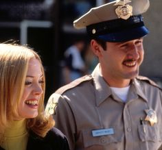 a man in uniform standing next to a woman smiling at each other's side