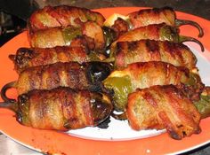 some meat wrapped in peppers on an orange plate