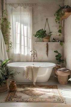 a white bath tub sitting under a window next to a rug and potted plants