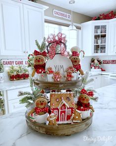 two tiered trays filled with gingerbread houses and christmas decorations on top of a kitchen counter