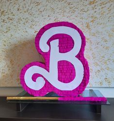 the letter b is made out of legos and sits on top of a table