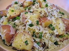 a bowl filled with potatoes and onions on top of a wooden table