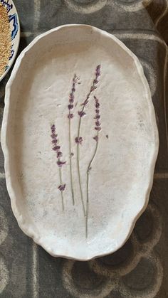 two plates with flowers painted on them sitting on a table