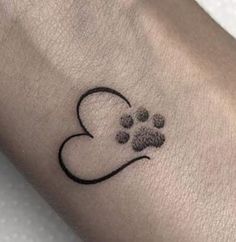 a dog paw and heart tattoo on the wrist