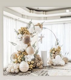 a white and gold christmas tree in a living room with balloons on the top of it