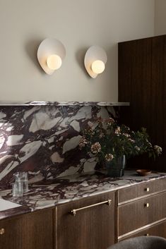 two lights are on above a marble counter top