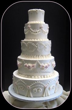 a white wedding cake with pink flowers and pearls