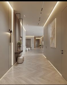 an empty hallway with wooden floors and white walls, illuminated by recessed lighting on either side