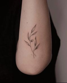 a woman's arm with a small tattoo design on the left side of her arm