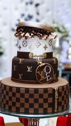 a three tiered cake with louis vuitton designs on the top and bottom