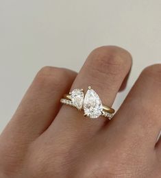 a woman's hand with three pear shaped diamond rings on top of her finger