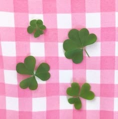 four leaf clovers on a pink and white checkered tablecloth