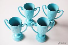 four blue vases sitting next to each other on a white table top with the tops turned upside down