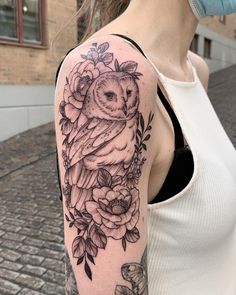 an owl and flowers tattoo on the arm