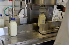 the milk is being poured into bottles on the machine