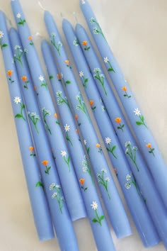 six blue candles with flowers painted on them