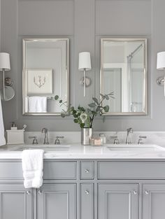 a bathroom with two sinks and mirrors on the wall