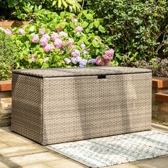 an outdoor storage box with flowers in the background