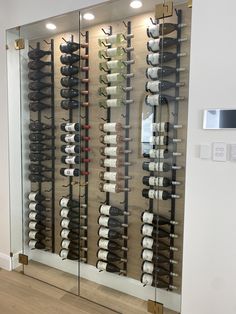 a wine cellar with many bottles of wine in the wall and on the glass door