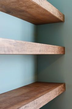 two wooden shelves against a blue wall