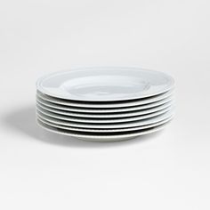 white plates stacked on top of each other in front of a white background with no one around them