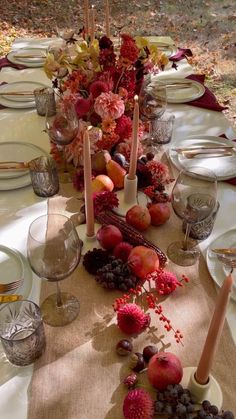 the table is set with fruit and candles