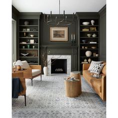 a living room filled with furniture and a fire place under a chandelier in front of a fireplace