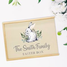 the smith family easter box with white flowers and greenery around it on a table