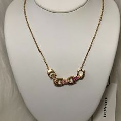 Coach Pave Signature Linked Necklace *New With Tags *Gold-Tone Chain Necklace (16") *Gold-Tone Pave Signature Linked *Pave Colors: Clear, Pink, Hot Pink Chic Pink Chain Jewelry, Chic Pink Necklace With Adjustable Chain, Pink Necklace With Gold Chain For Gift, Chic Coach Jewelry As Gift, Chic Coach Jewelry As A Gift, Elegant Pink Jewelry With Gold Chain, Pink Gold Chain Necklace For Gift, Pink Jewelry With Gold Chain, Circle Stone Necklace